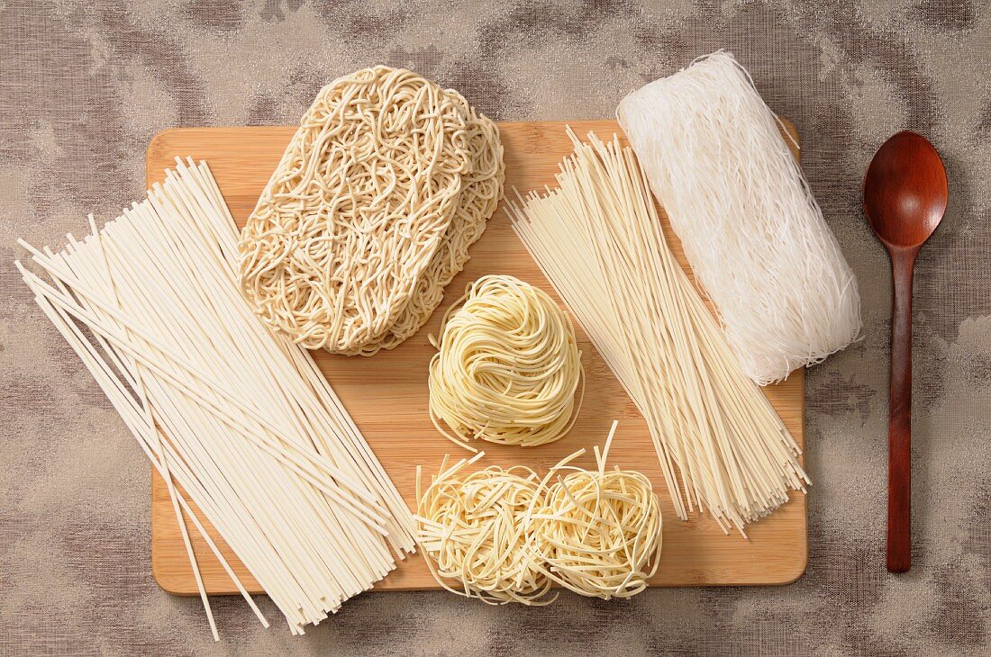 Assorted types of Asian noodles on a chopping board