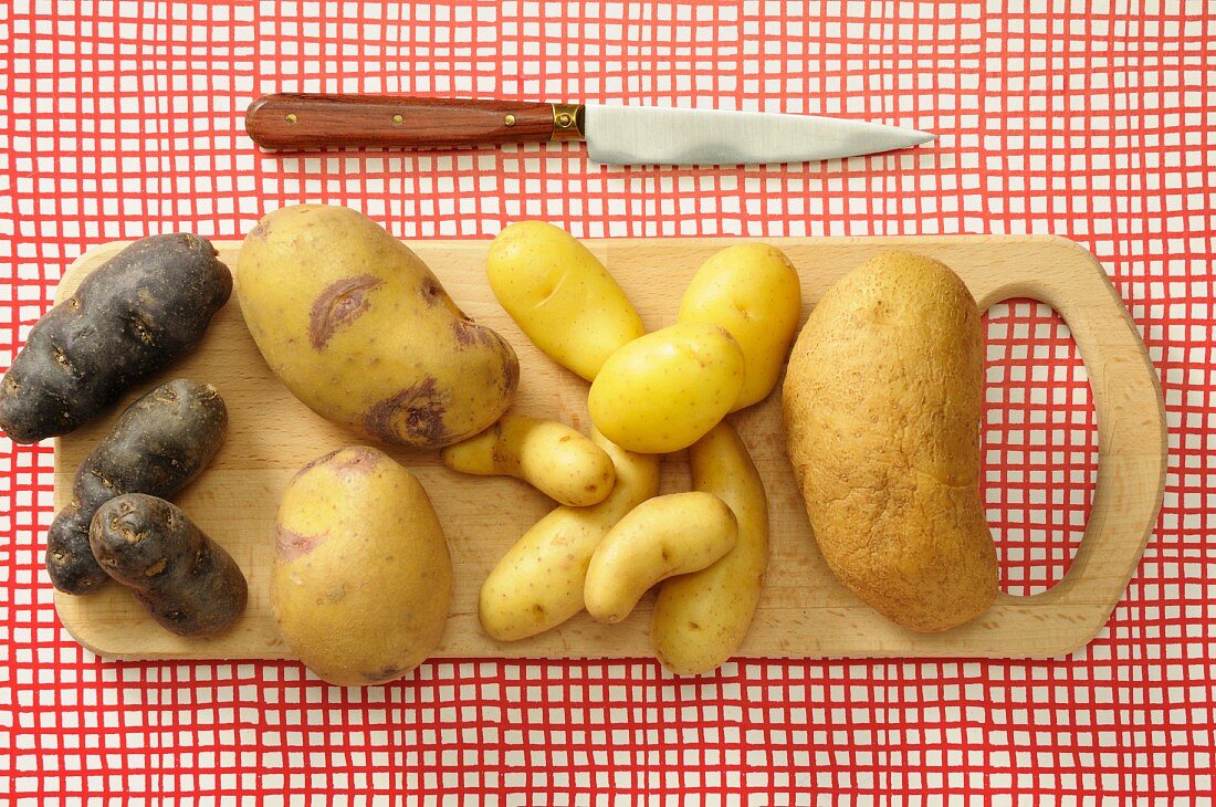 Assorted types of potato on a chopping board