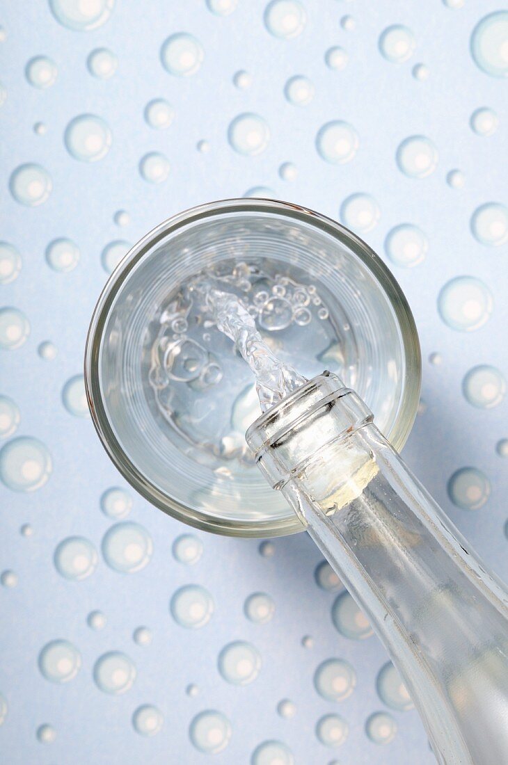 Wasser in ein Glas einschenken