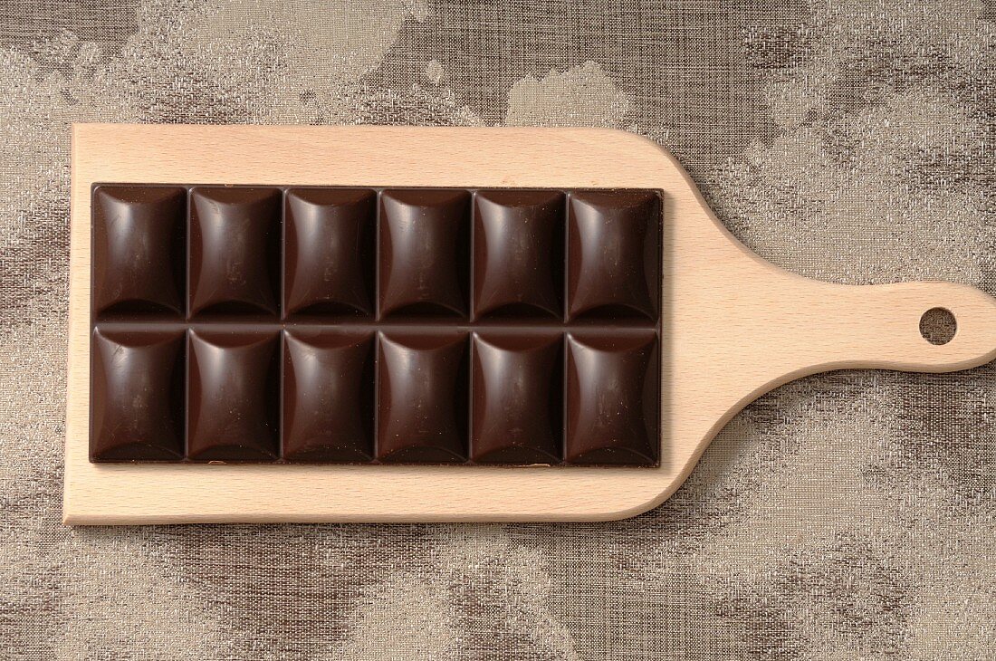 A bar of chocolate on a chopping board