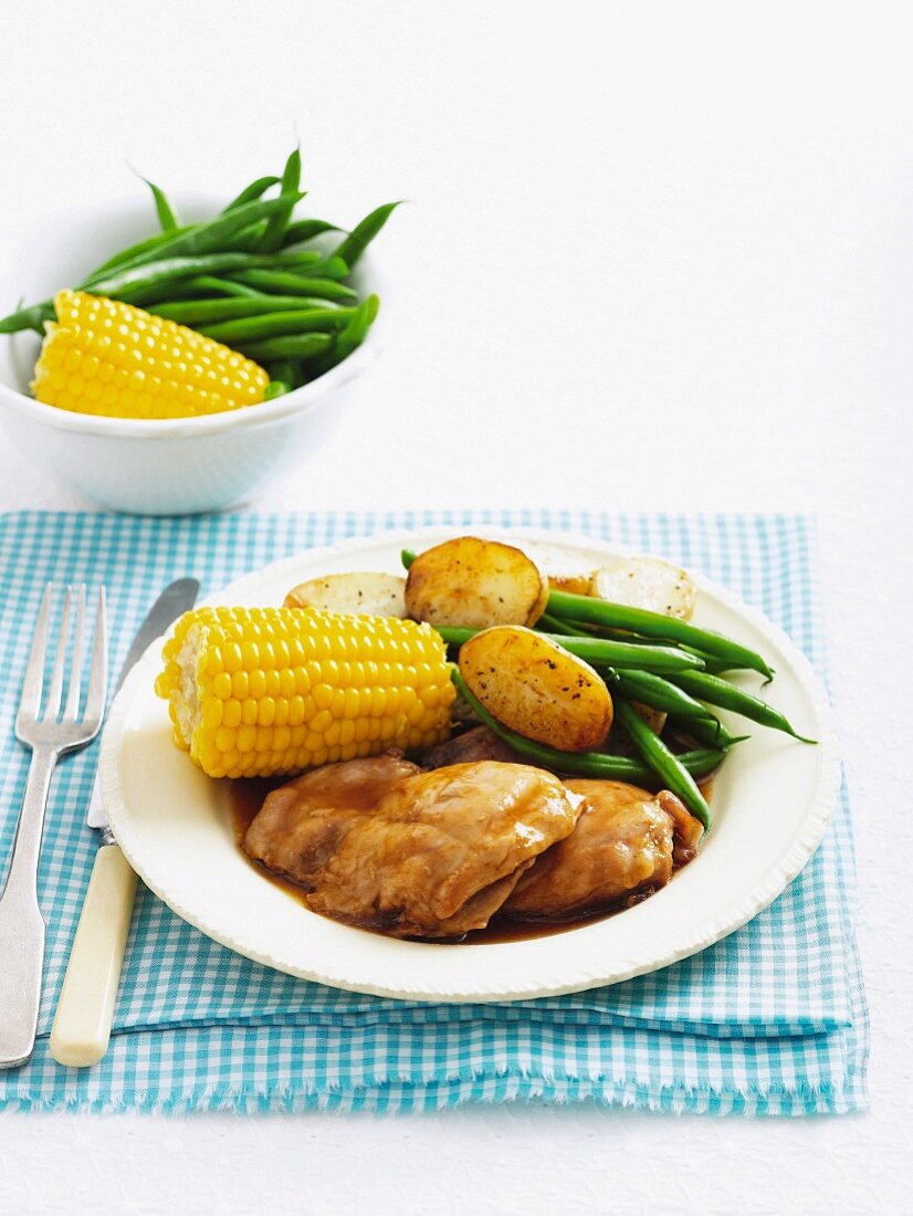 Chicken with apple glaze, corn on the cob, green beans and potatoes