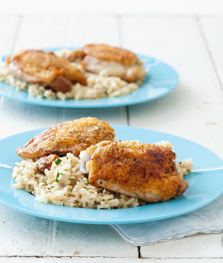 Dinner for Two: gebratene Hähnchenschenkel mit Reis auf blauen Tellern