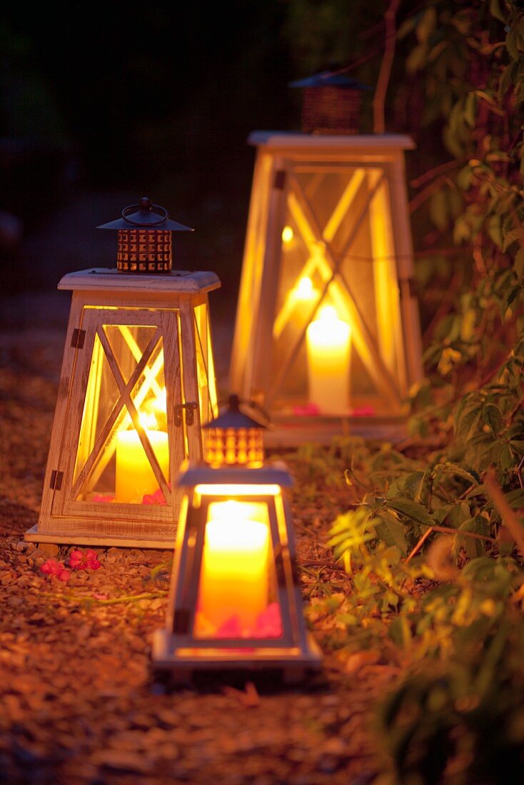 Lanterns with candles illuminating a garden path