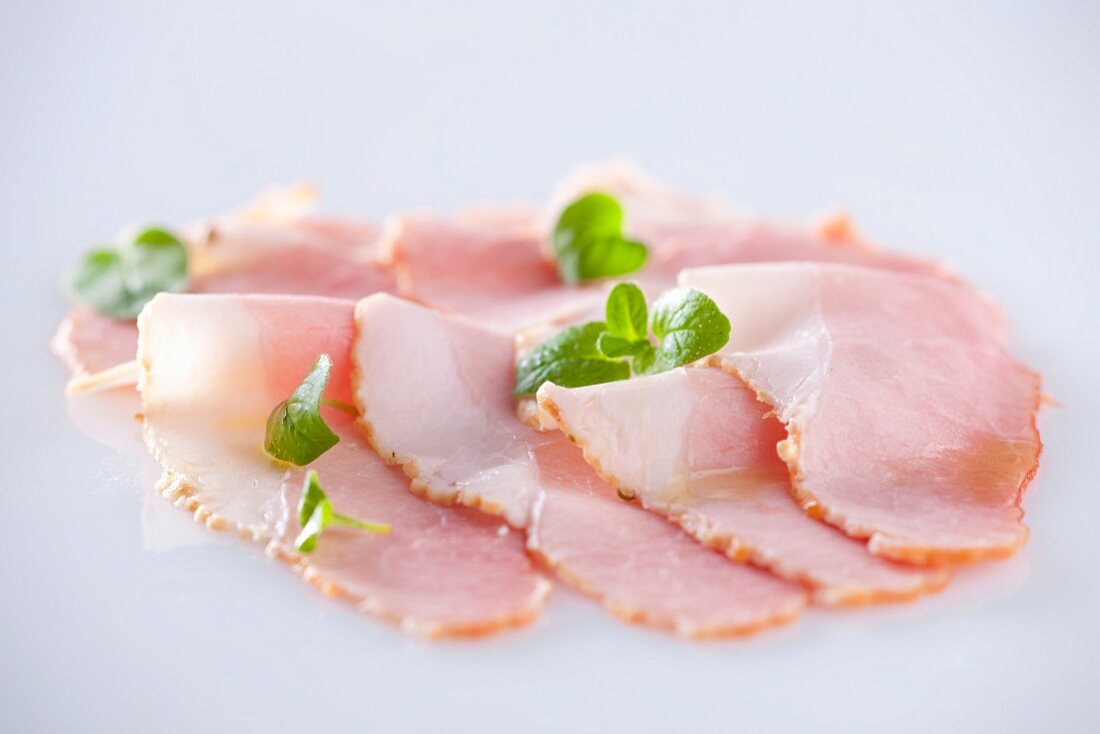 Slices of ham with oregano leaves