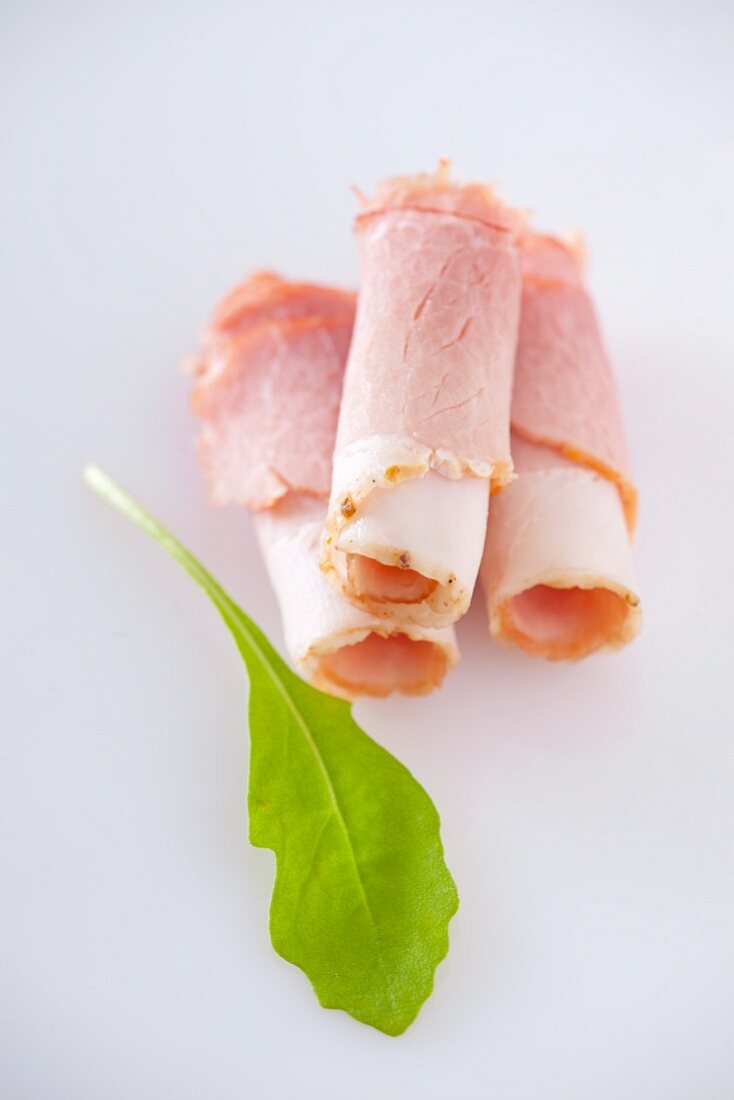 Rolled ham slices and a rocket leaf