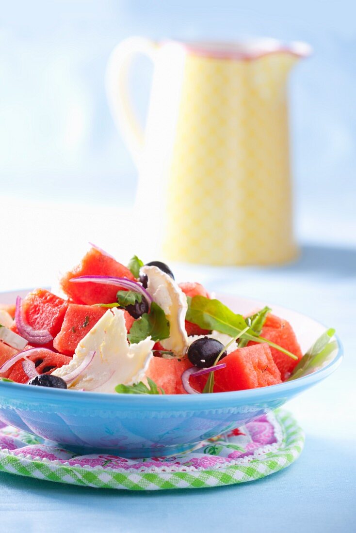 Wassermelonensalat mit Ziegenkäse, roten Zwiebeln, Oliven und Rucola