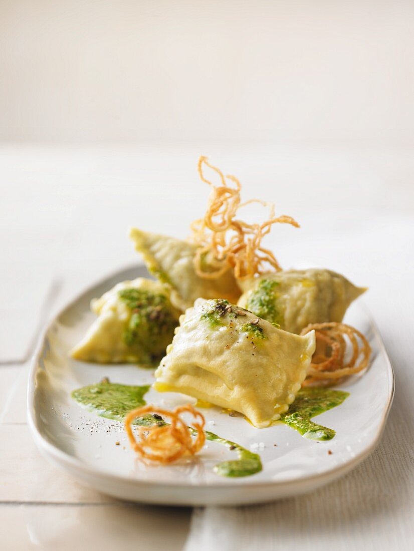 Ravioli with herb sauce and fried onions