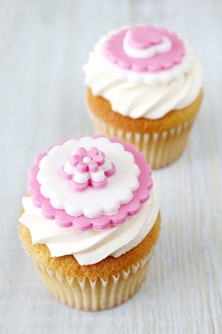 Cupcakes decorated with white and pink sugar flowers