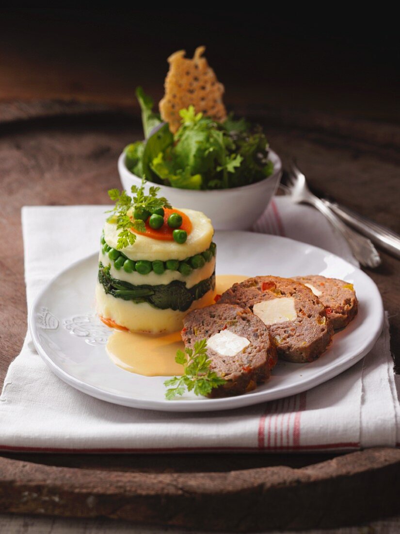Meat loaf with a mashed potato and vegetable tower