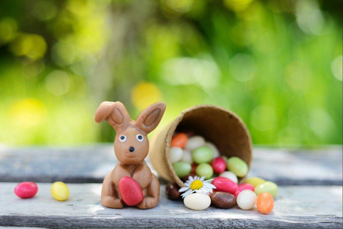 Schokoladenhase und Jelly Beans auf Gartentisch