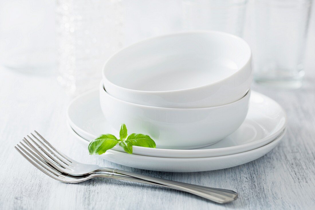 Two dinner bowls with plates and forks