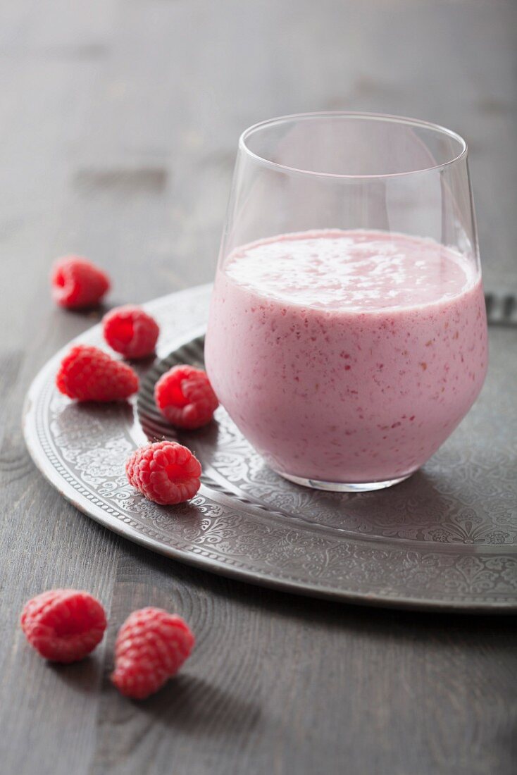 A raspberry milkshake and fresh raspberries
