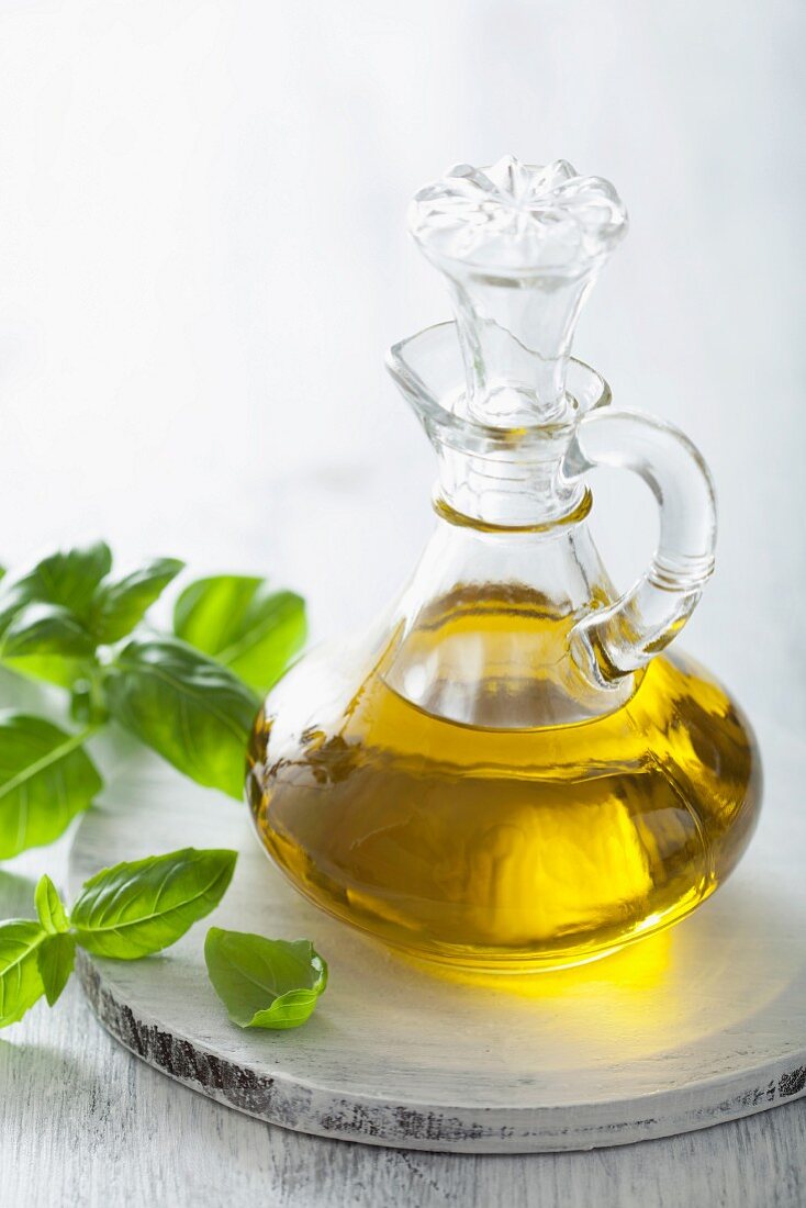 A carafe with olive oil and fresh basil