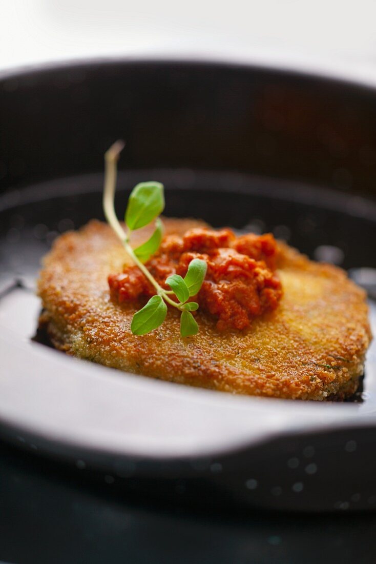 Paniertes Schweinekotelett mit Tomatensauce und Oregano