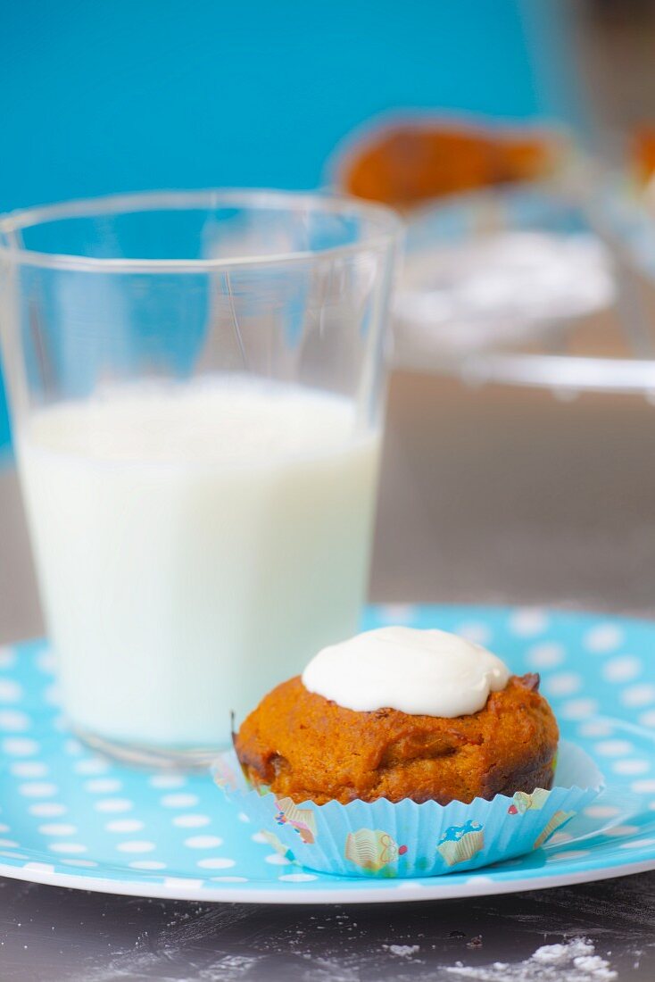 Carrot muffin with glacé icing and a glass of milk