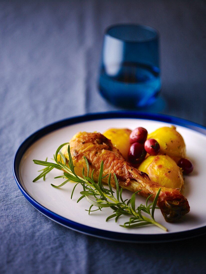 A chicken leg with roast potatoes, cranberries and rosemary