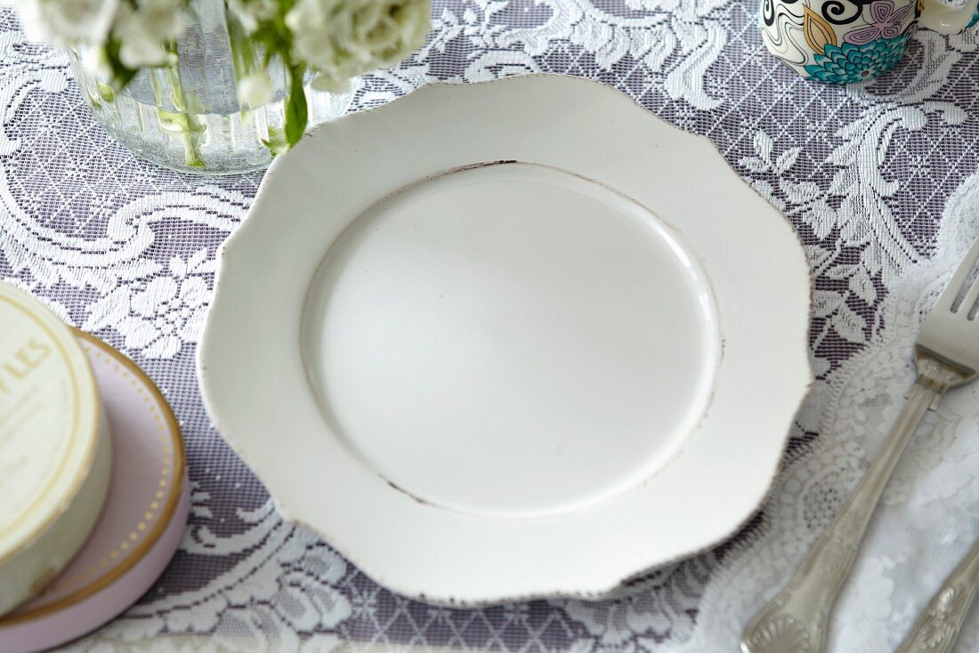 A white plate on a lace cloth