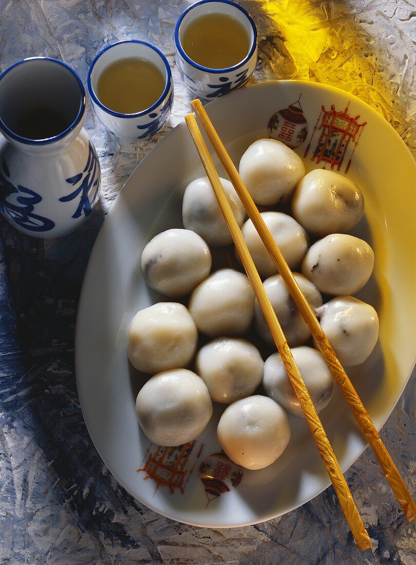 Sweet Rice Dumplings on a Platter with Chopsticks and Tea