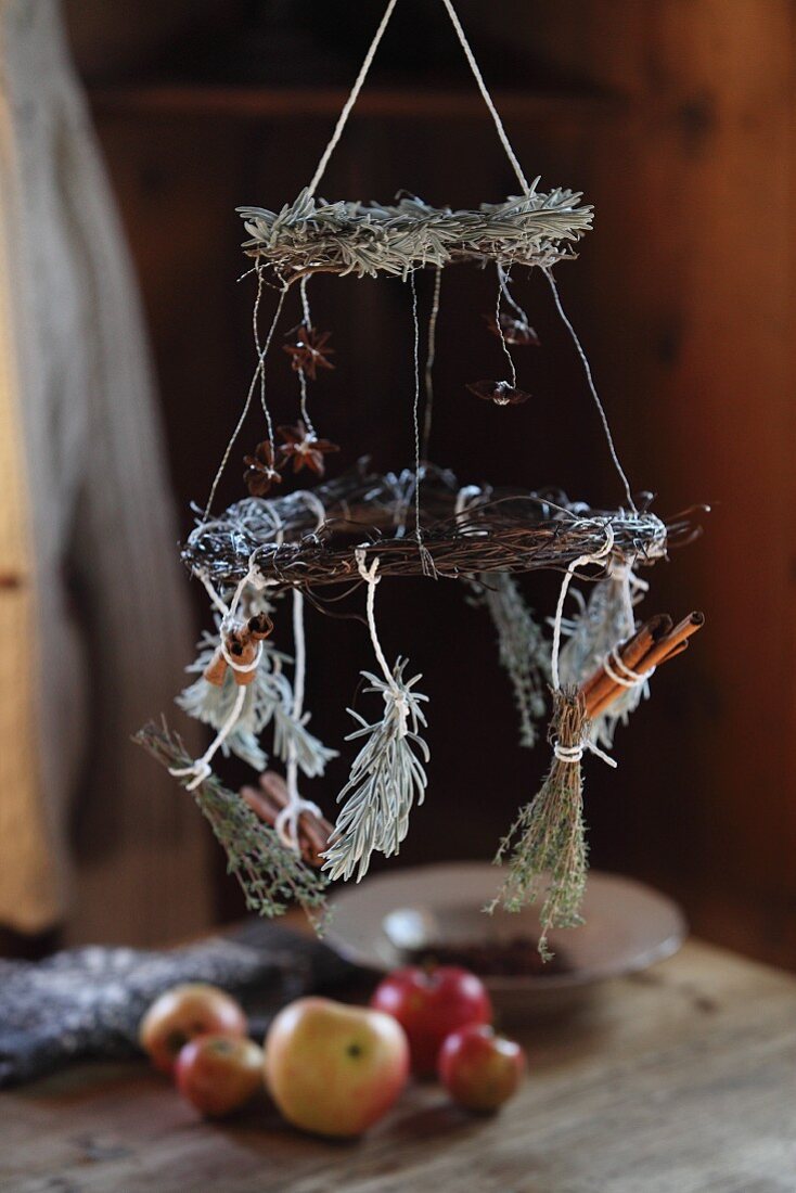 Festive, hand-crafted, suspended wreaths above apples on table