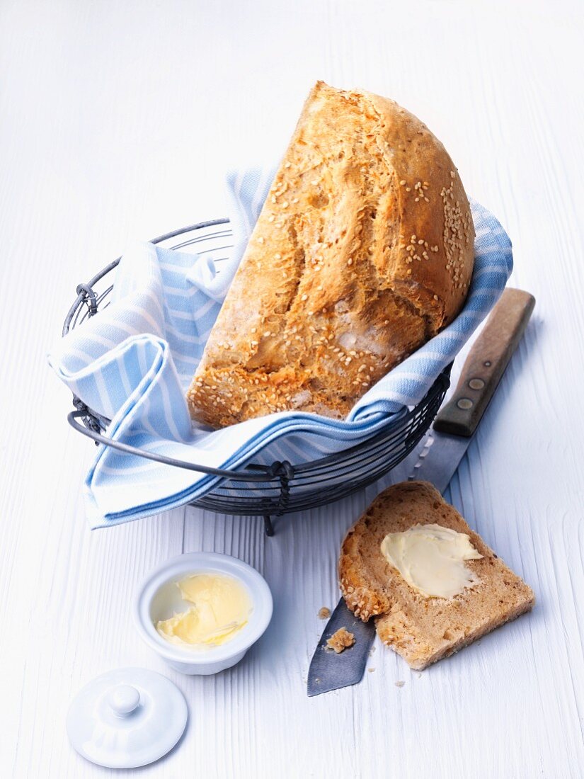 Joghurt-Sesam-Brot im Brotkorb, Butter