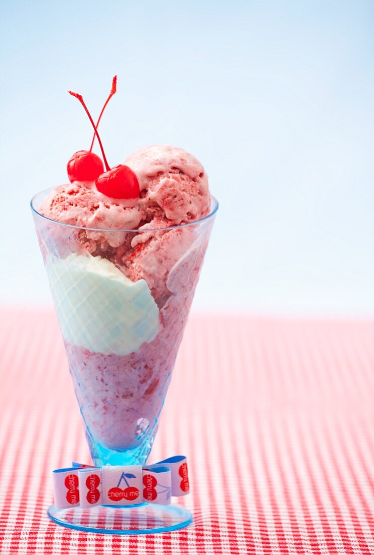A strawberry and vanilla ice cream sundae with glacé cherries