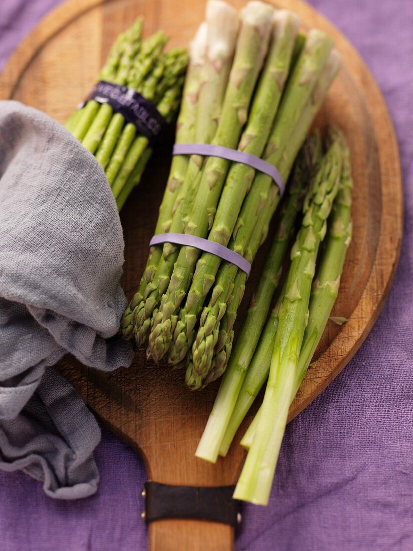 Green asparagus, bundled, on a chopping board