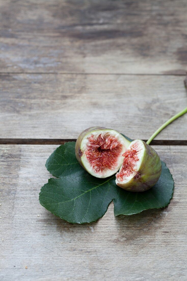 A halved fig on a fig leaf