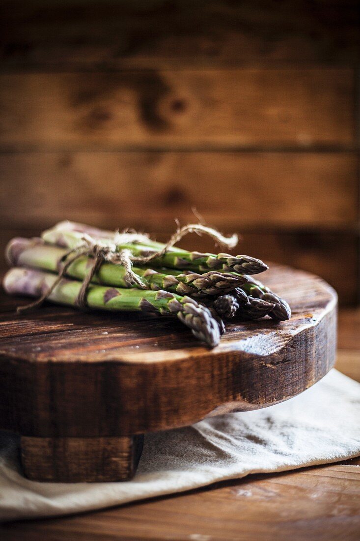 Ein Bund grüner Spargel auf Holzbrett