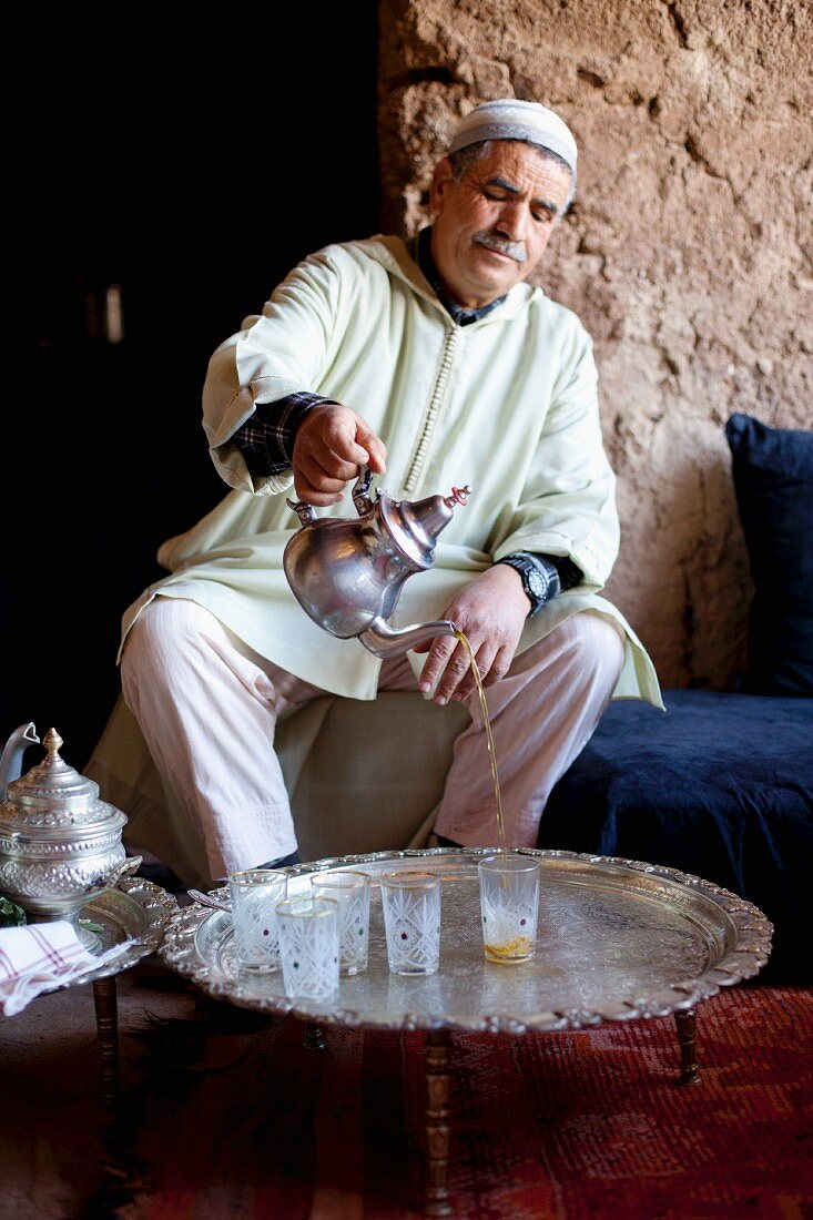 Nordafrikaner giesst Tee in Gläser