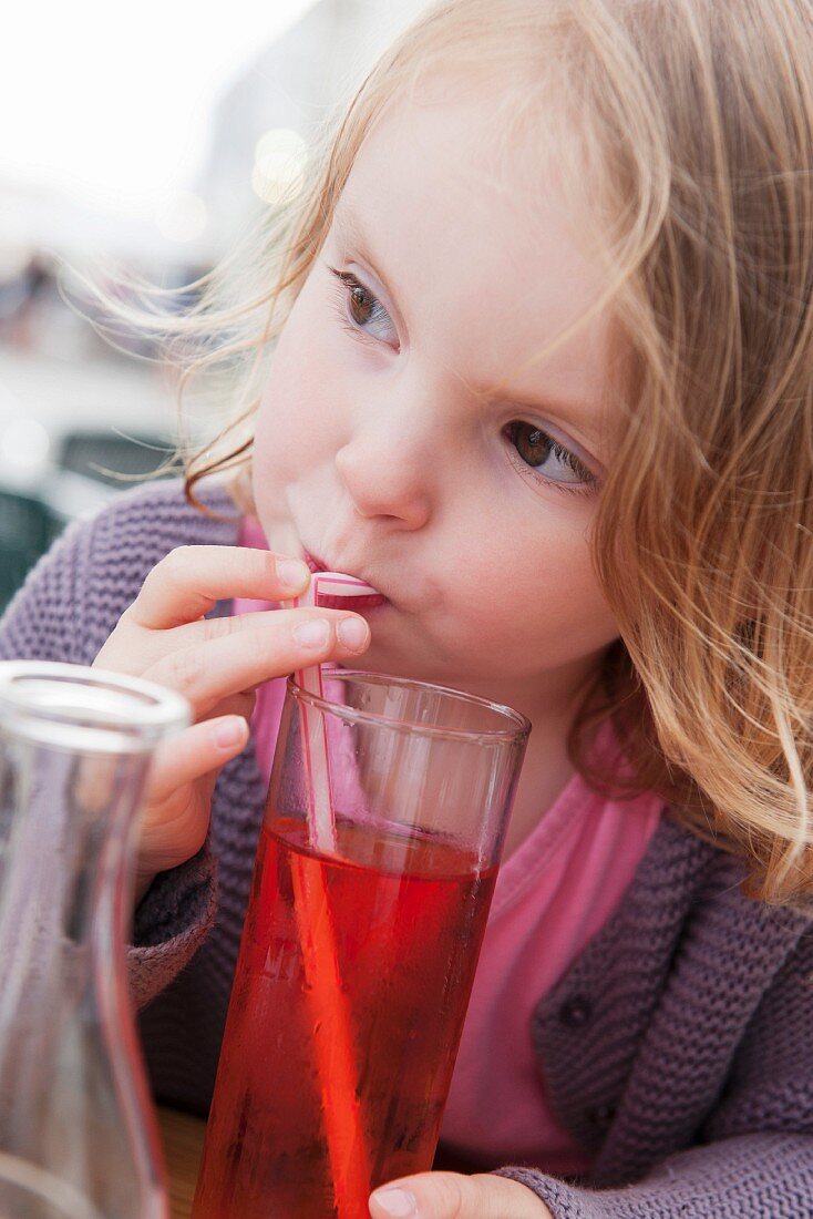 Little girl drinking fruit juice