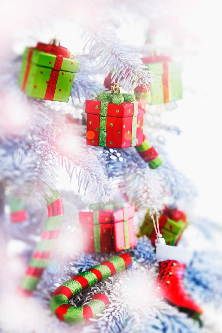 Weihnachtsbaum mit kleinen Geschenkpaketen als Baumanhänger und Zuckerstangen