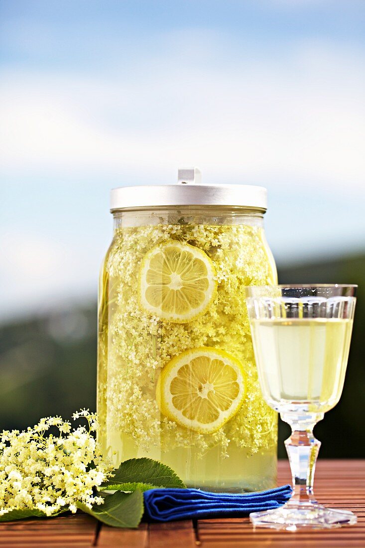 Home-made elderflower juice with slices of lemon in a storage jar