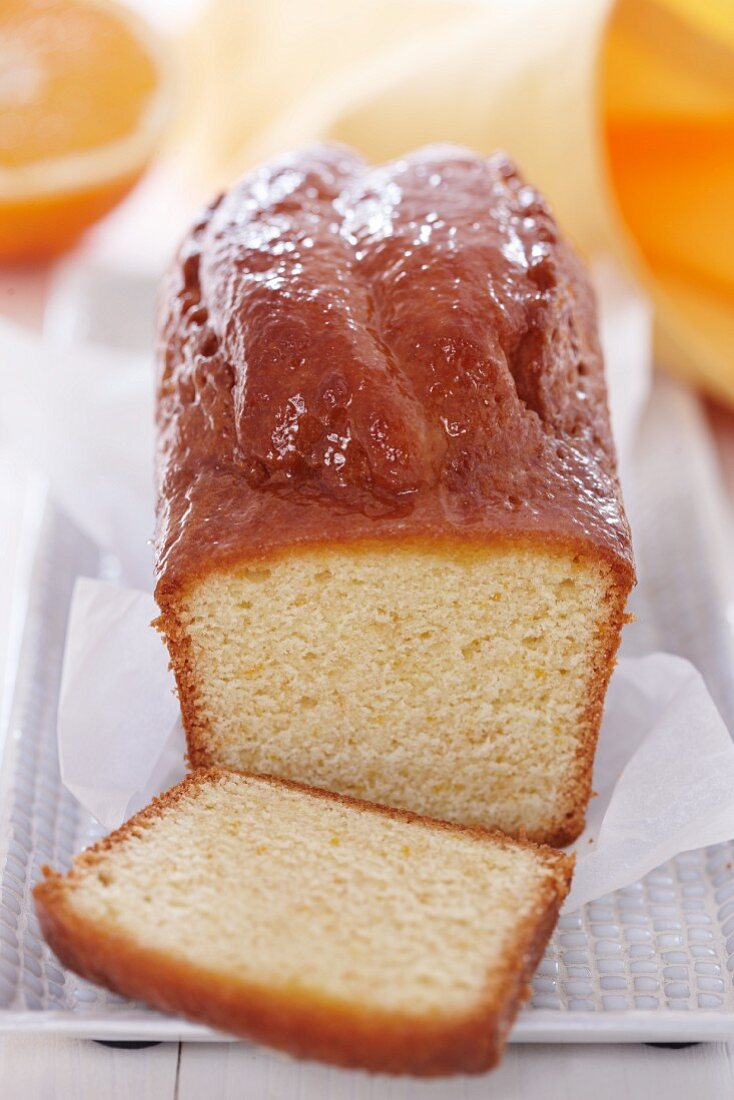 Orange cake, cooked in a loaf tin, partly sliced
