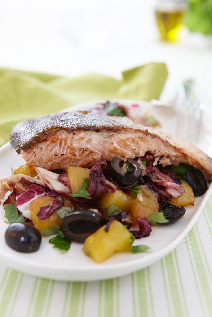 Salmon fillet on a bed of potato and radicchio salad with olives