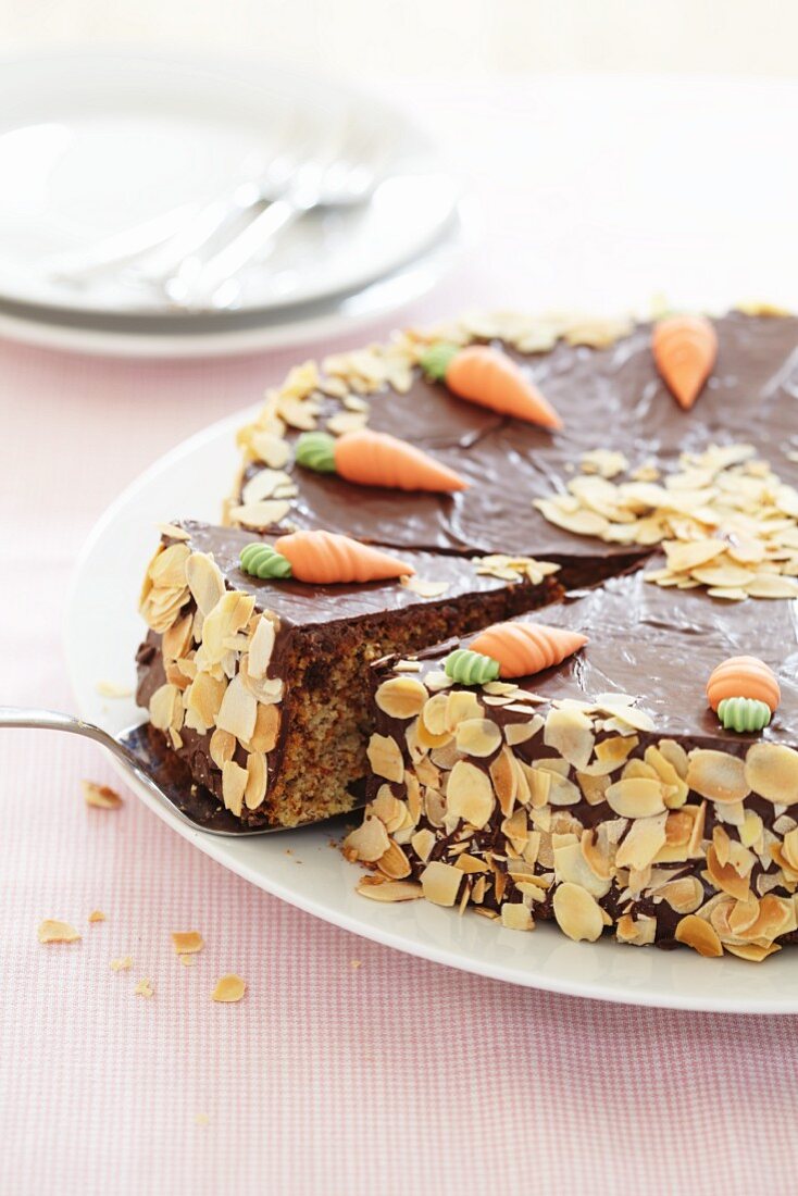 Carrot cake with chocolate topping and sliced almonds