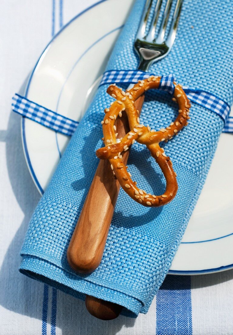A place setting in a beer garden with a napkin and pretzel