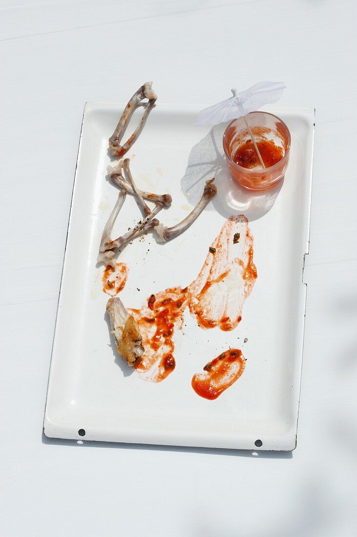 Reste von Chicken Wings mit Tomatensauce auf einem Backblech