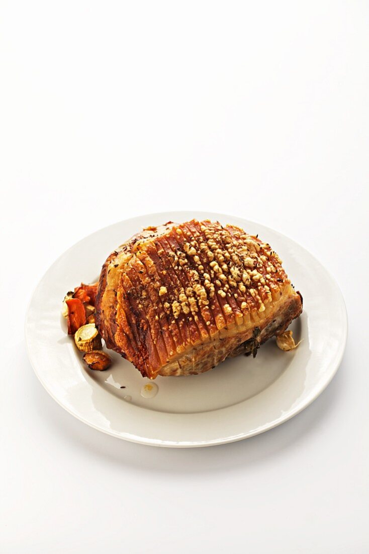 Whole roasted shoulder of pork on a white plate