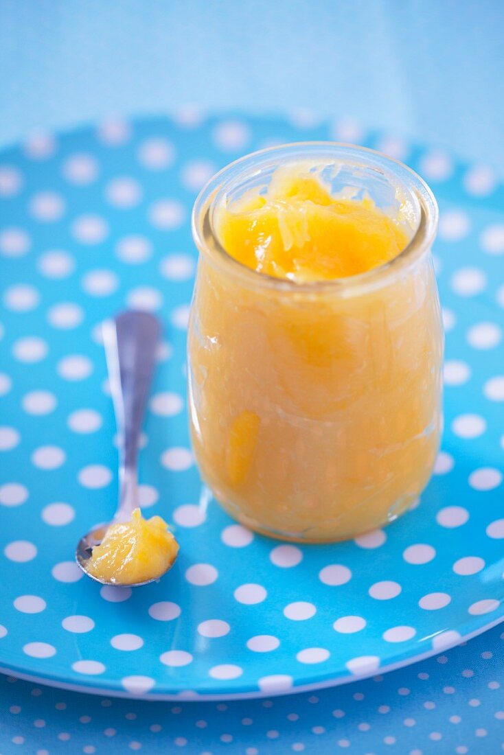 Lemon Curd im Glas auf gepunktetem Teller