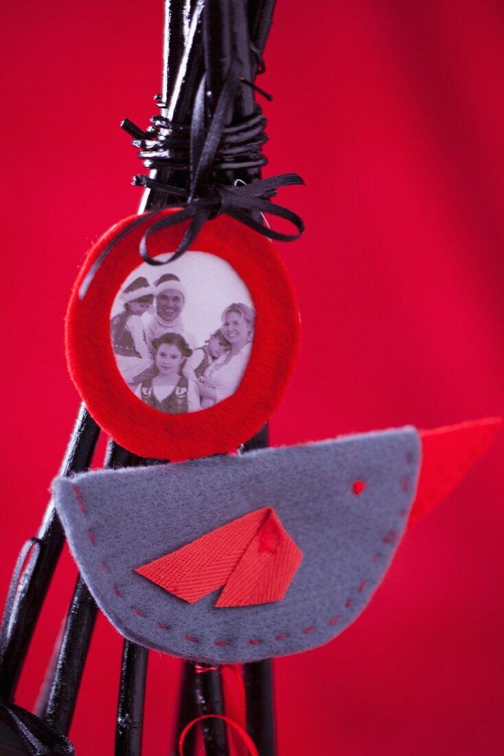 Family photograph and felt decoration on modern Christmas tree made of black-painted twigs