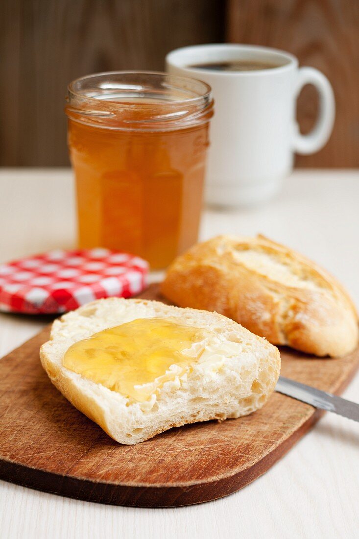 A bread roll spread with elderflower jam