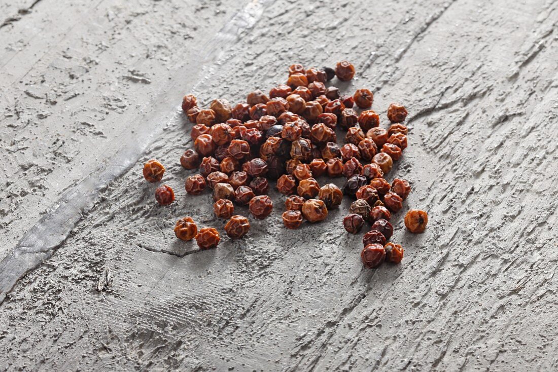 Red peppercorns on grey wood