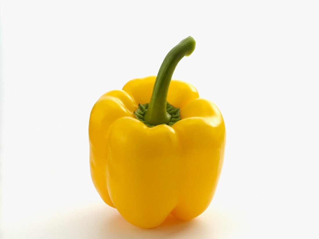 A yellow pepper on a white surface