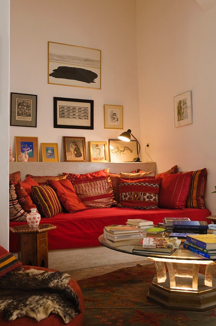 Marokkanische Sitzecke in einer Wandnische mit Bildergalerie über gemauertem Sofa