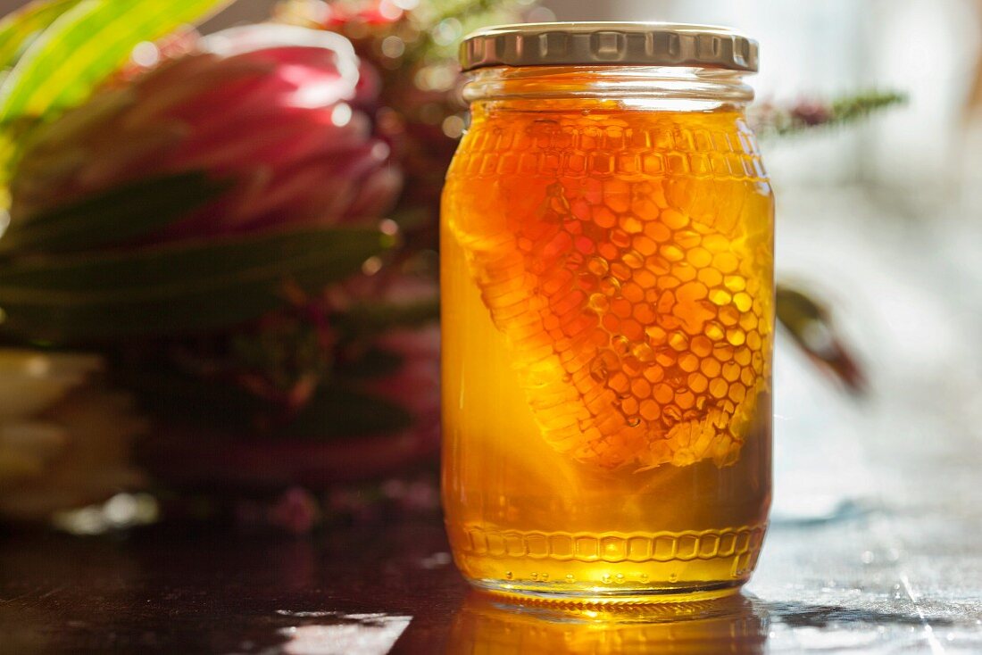 Honey with honeycomb in a screw-top jar