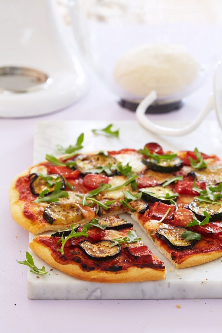 Vegetable pizza topped with peppers, courgette and rocket