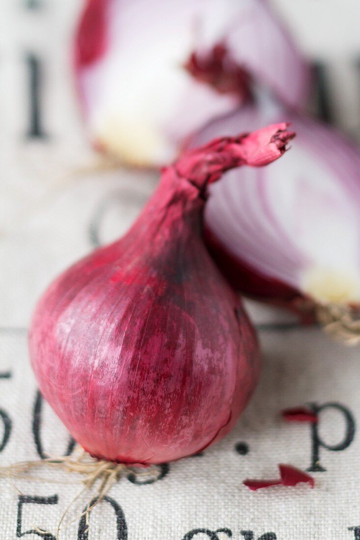 A halved and a whole red onion