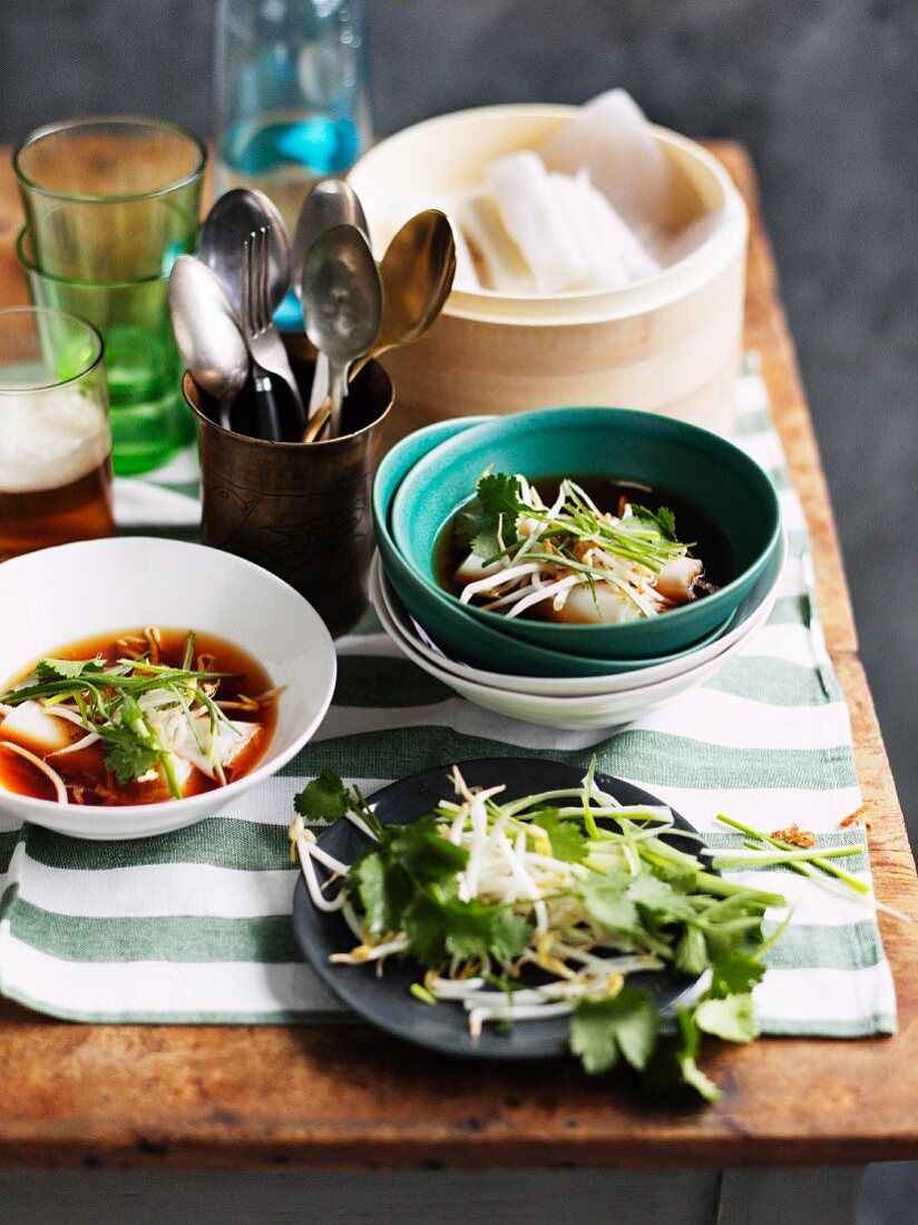 Broth with rice noodle rolls and bean sprouts