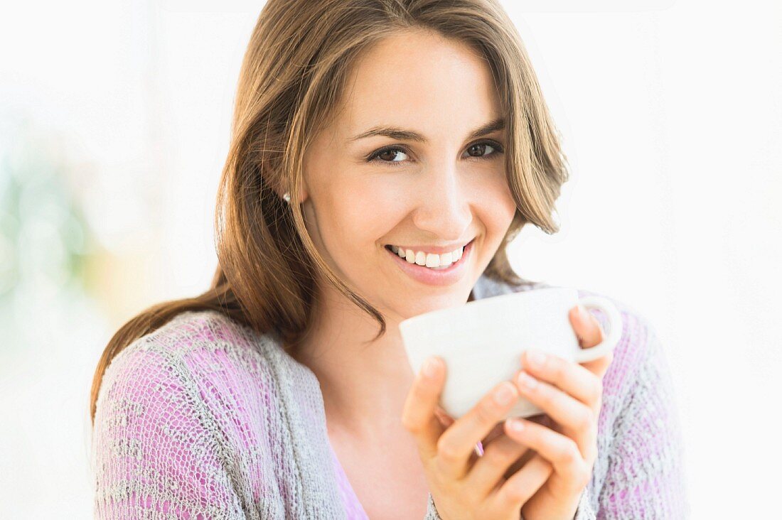 Junge Frau hält Tasse in den Händen