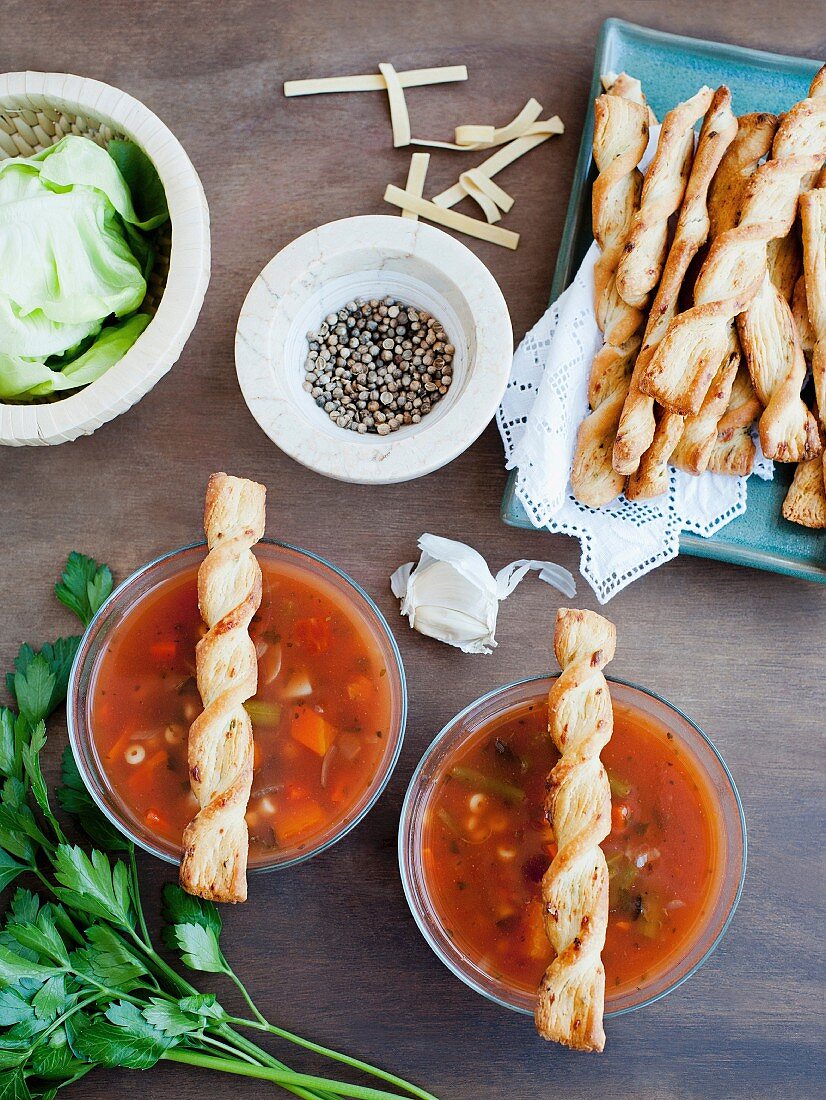 Vegetable soup in glass bowls served with breadsticks